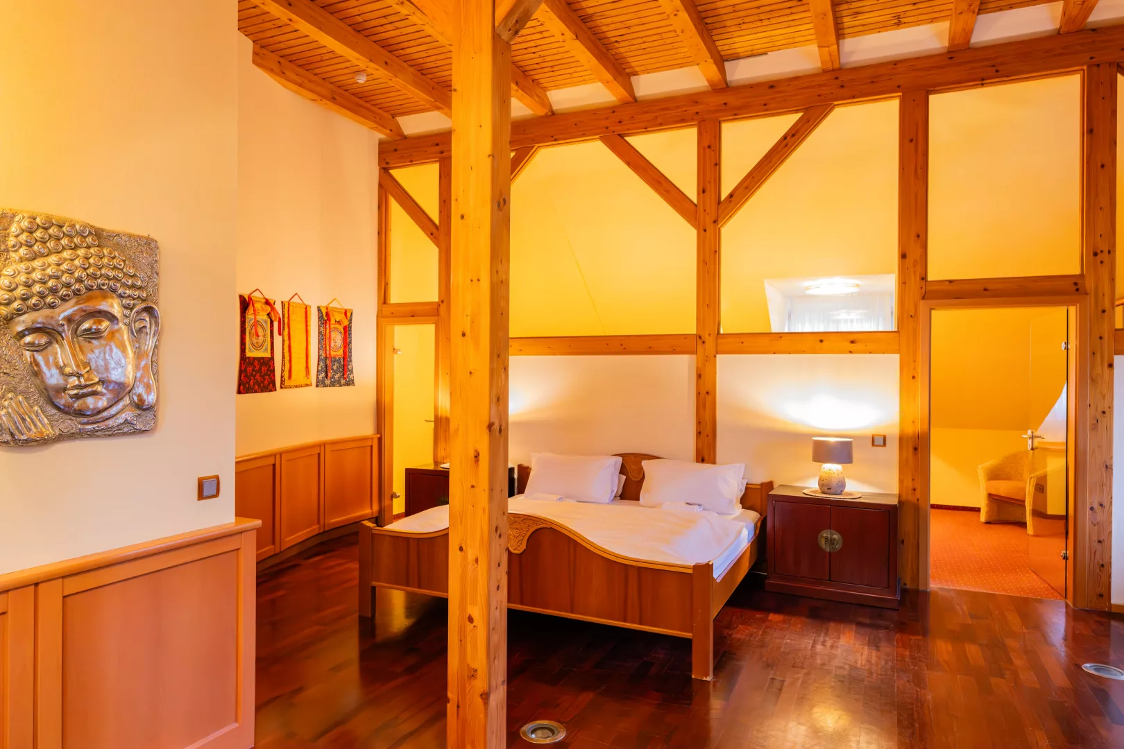 Ein Schlafzimmer aus dem Apartment 12, Fachwerkhaus, Doppelbett mit Nachttisch und ein weiterer Raum abgetrennt im Hintergrund