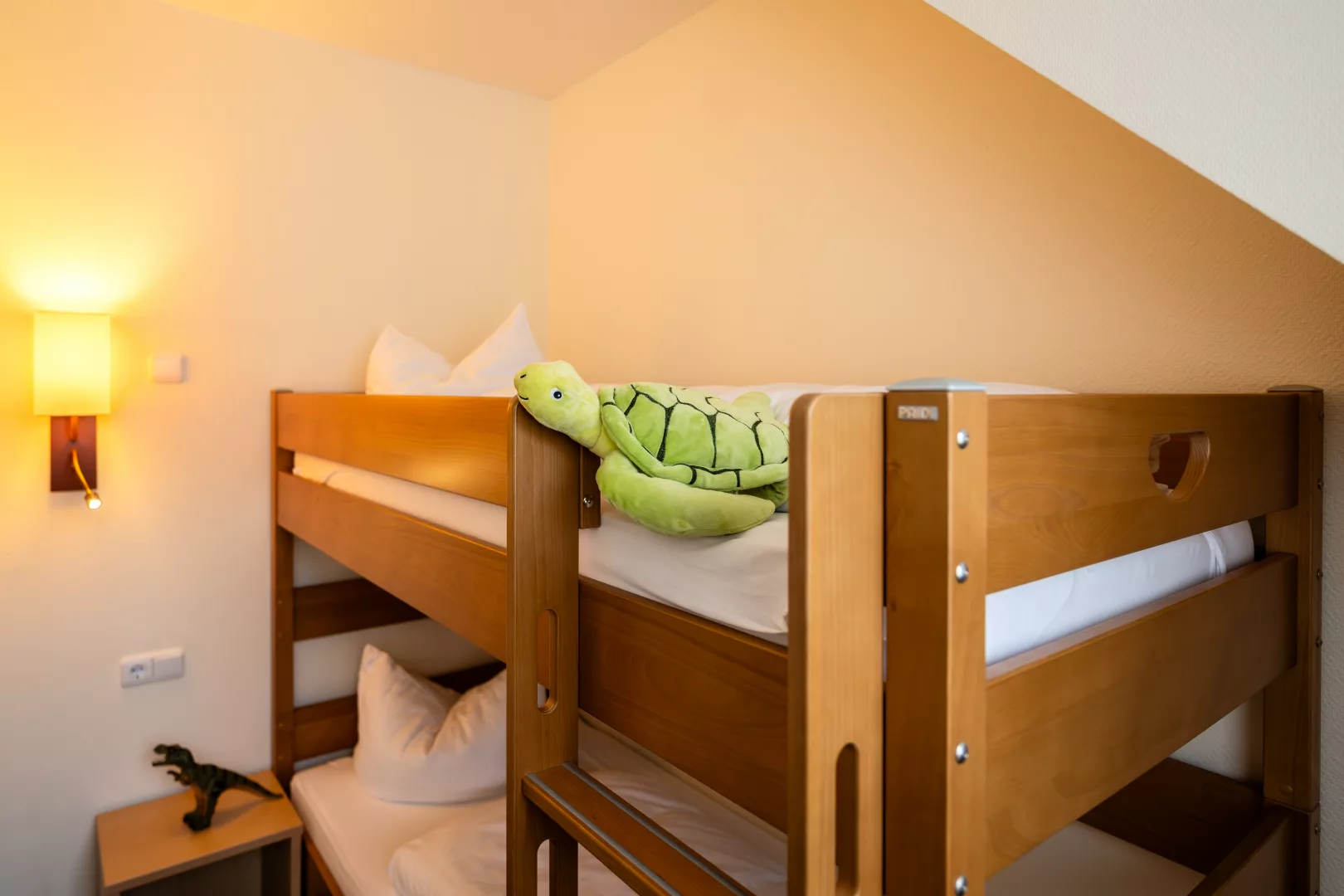 Kinderzimmer im Familienzimmer des Hotels Zeitgeist mit Etagenbett aus Holz, einer Lampe und Spielzeug