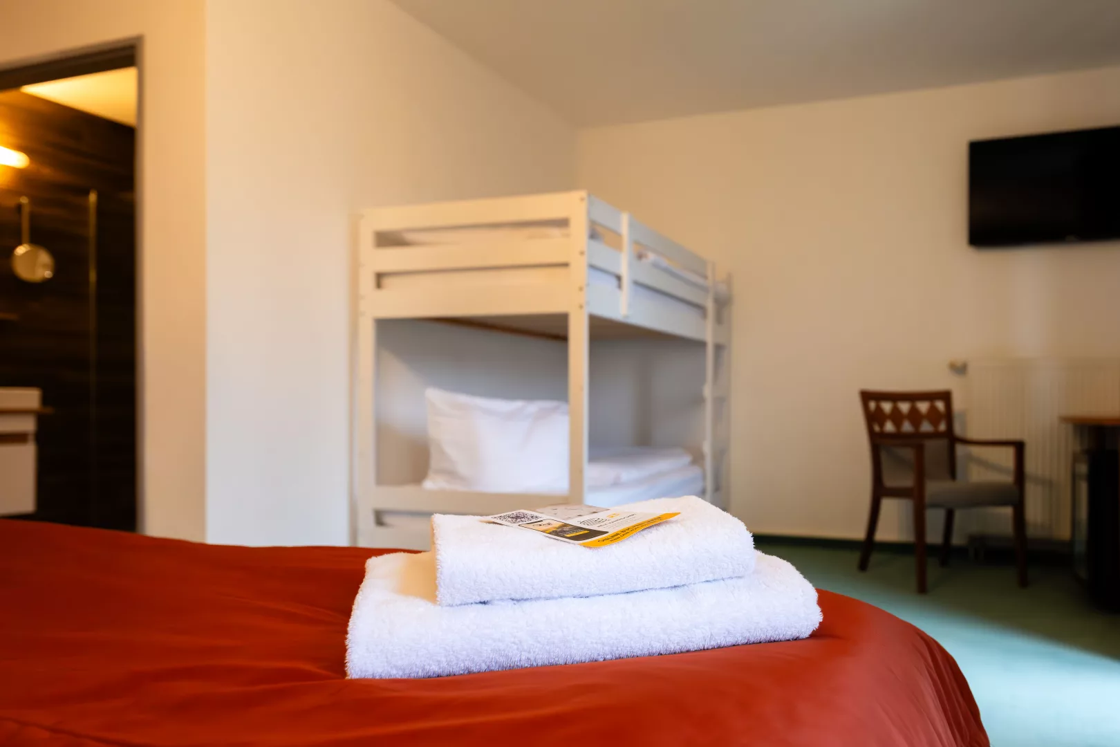 Etagenbett aus dem Vierbettzimmer im Parkhotel Hohnstein aus Holz, mit Sitzecke und Fernseher